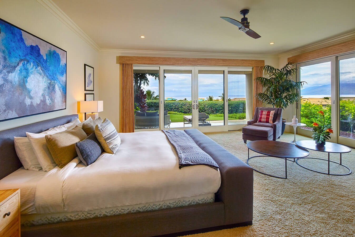 king bed and seating area in Ho'olei Villas with patio doors give view of outside