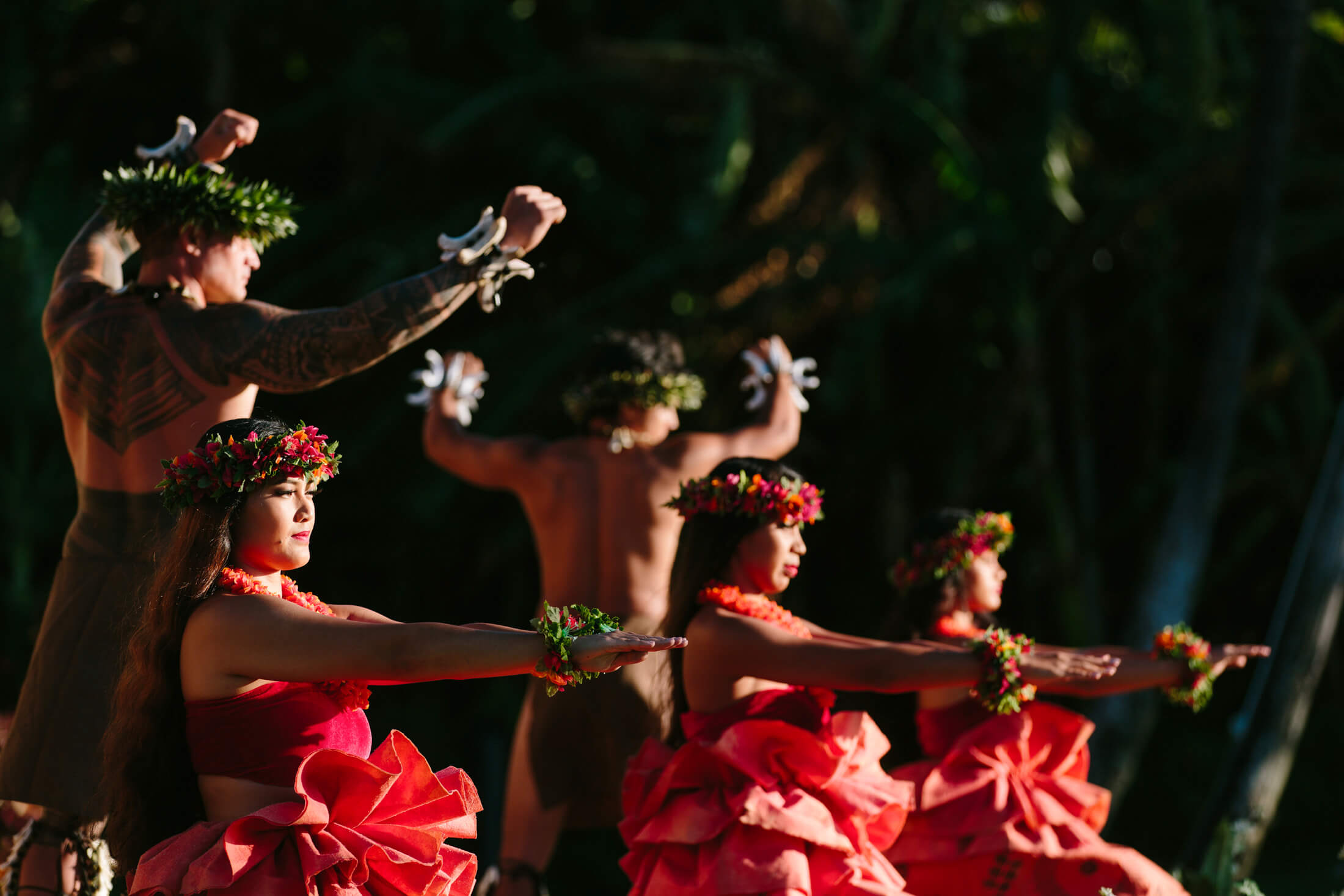 a group of women in red and men dance on a stage