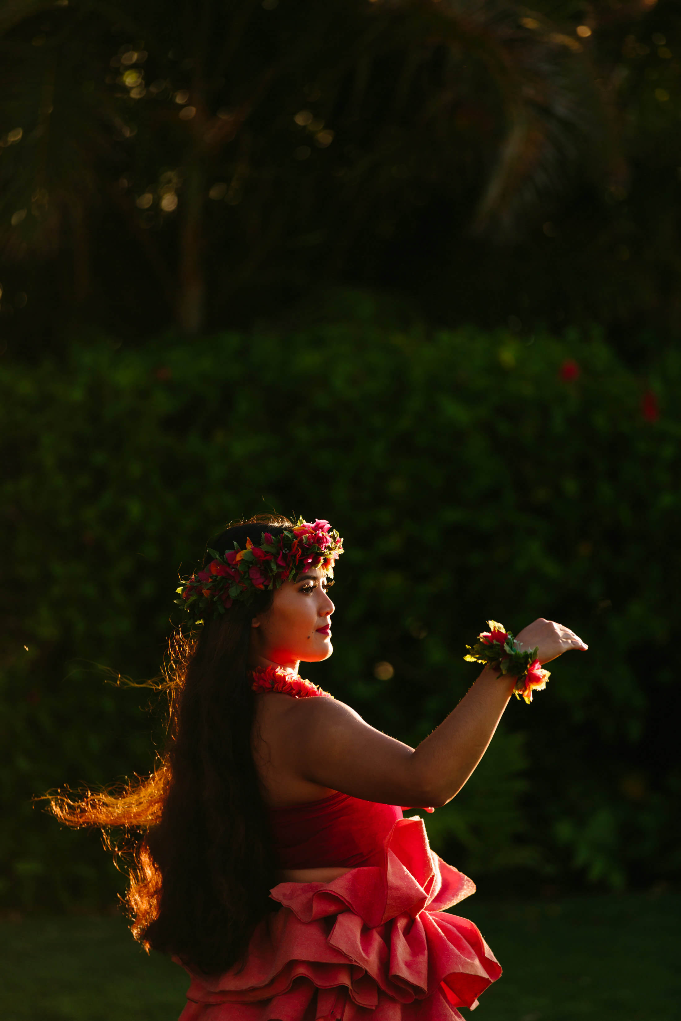 a woman dressed in red dances the luau outside 