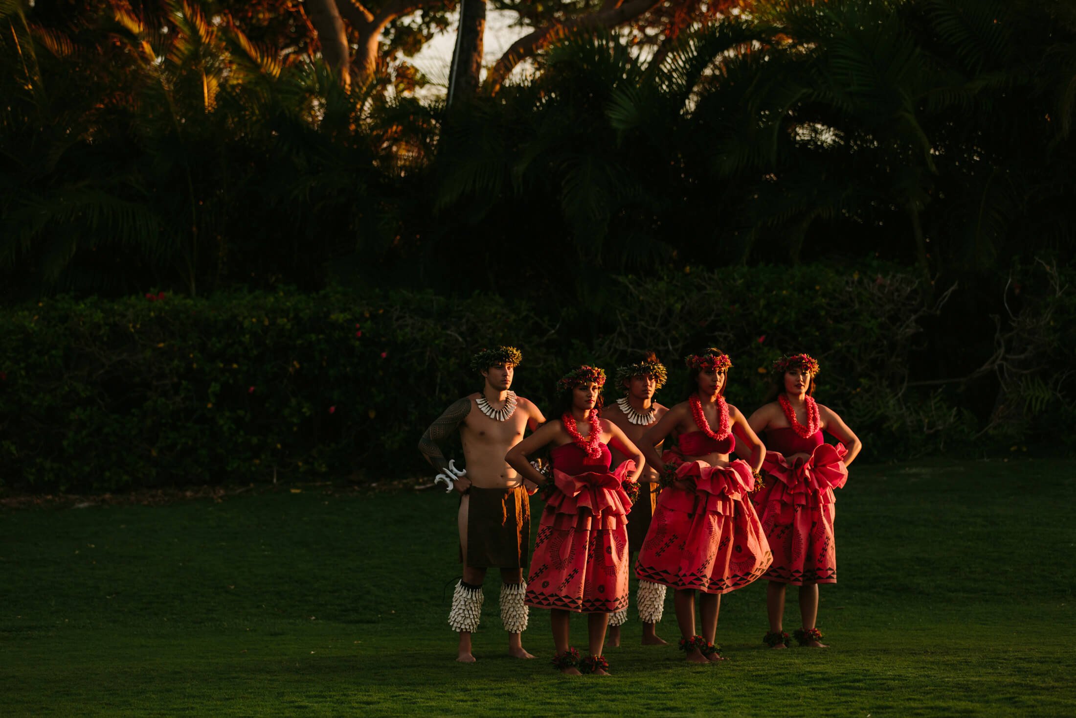 a group of women in red and men dance in a field