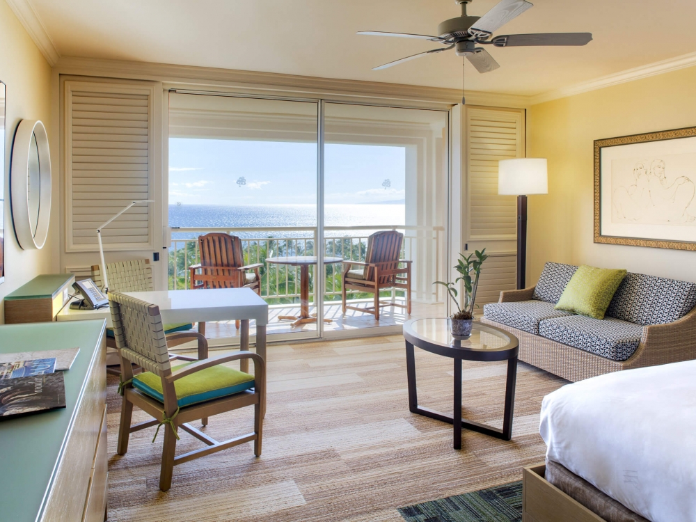 bed and seating area in King Oceanview room with patio doors give view of outside