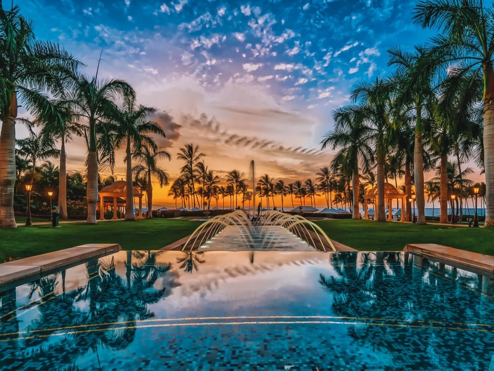 view of the Grand Wailea resort and pool with a dark blue and orange sky