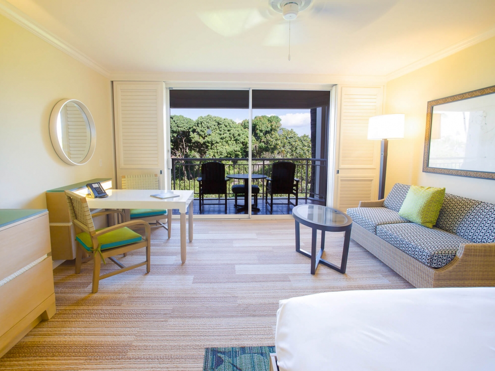 bed and seating area in King Garden view room with patio doors give view of outside