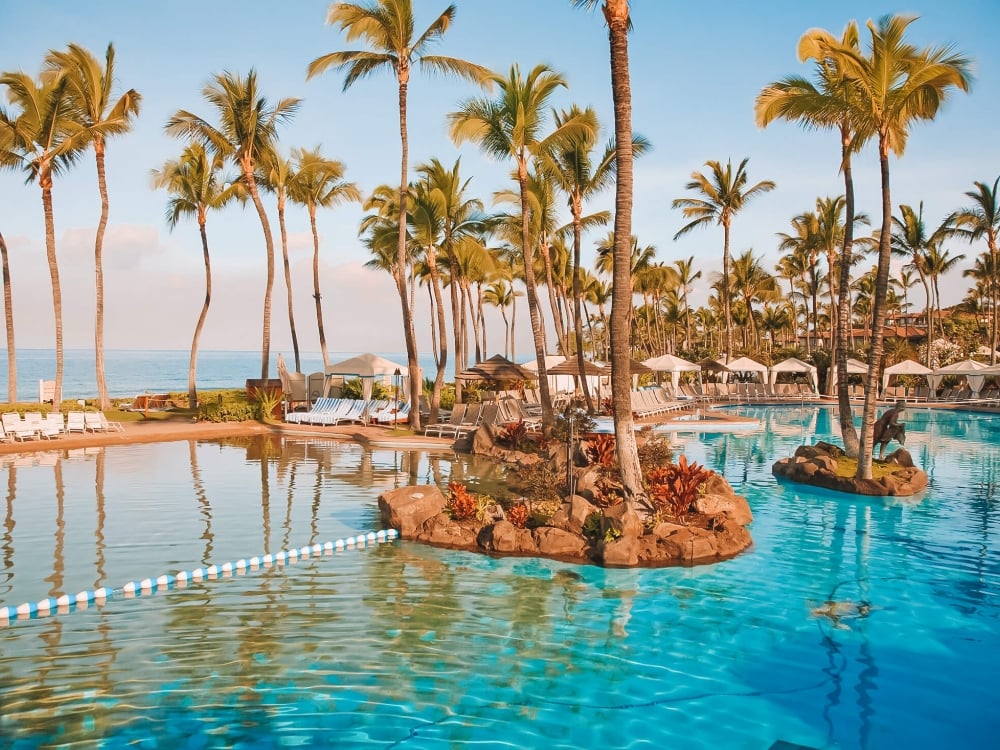 close up of blue water in Grand Wailea pool with palm trees and ocean in the background