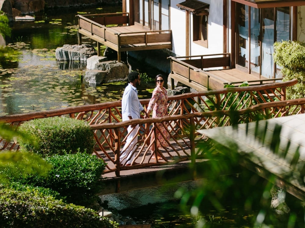 a couple walks across a wooden balcony