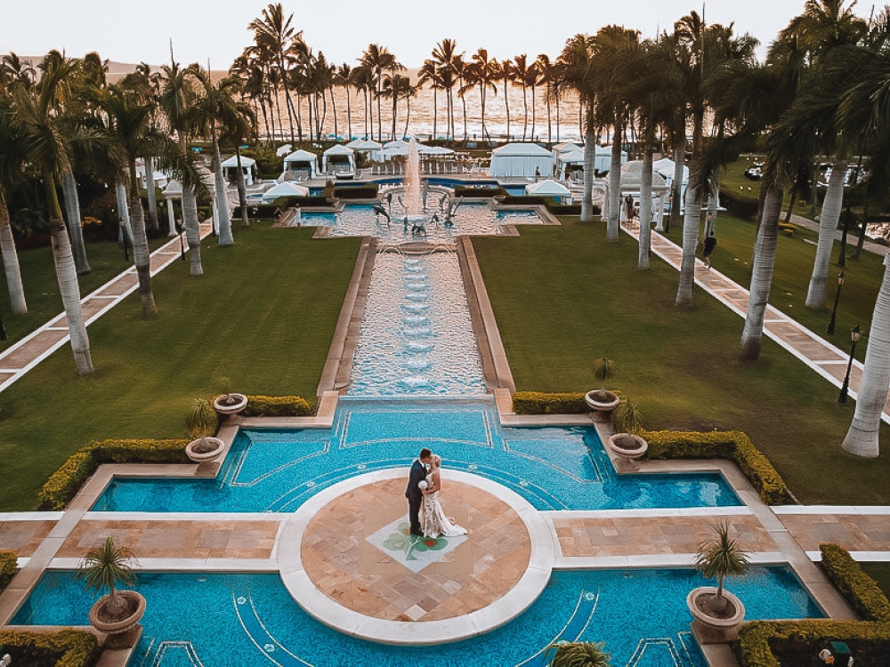 bride and groom stand on platfrom in the middle of Grand Wailea pool