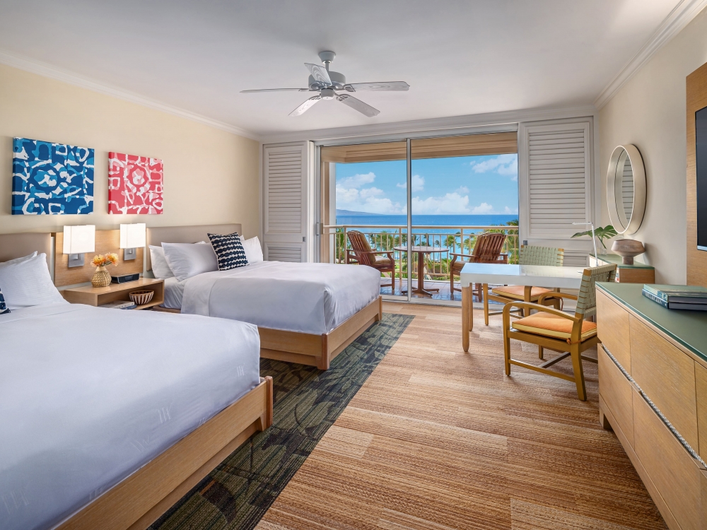 two beds and seating areas in Deluxe Ocean View Queen room with patio doors give view of outside