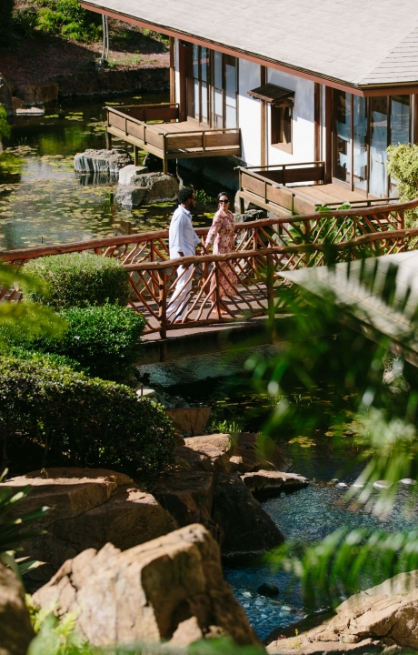 a couple walks across a wooden balcony