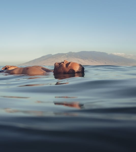 A man floats on his back in the sea