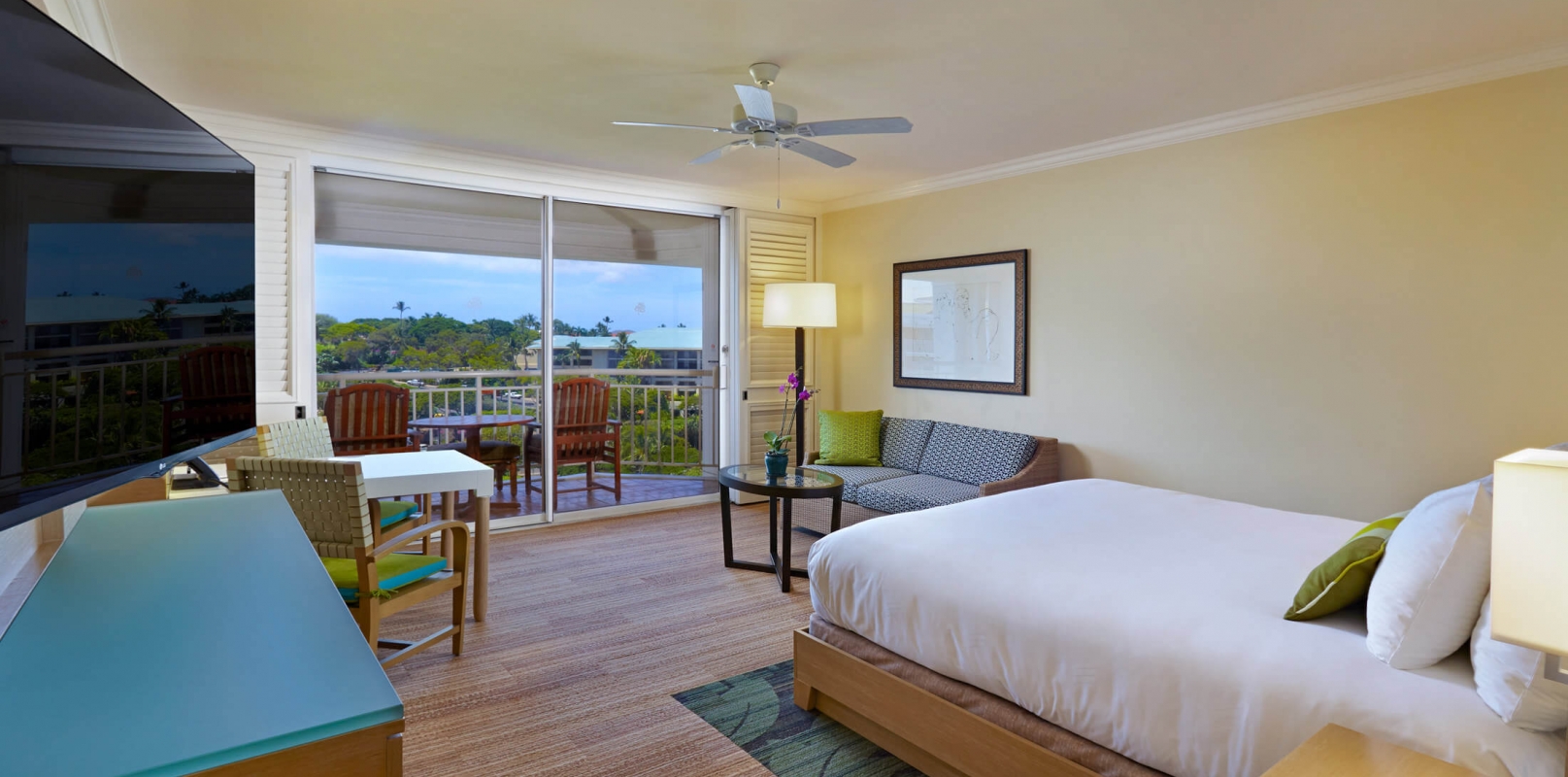 bed and seating area in King Terrace room with patio doors give view of outside