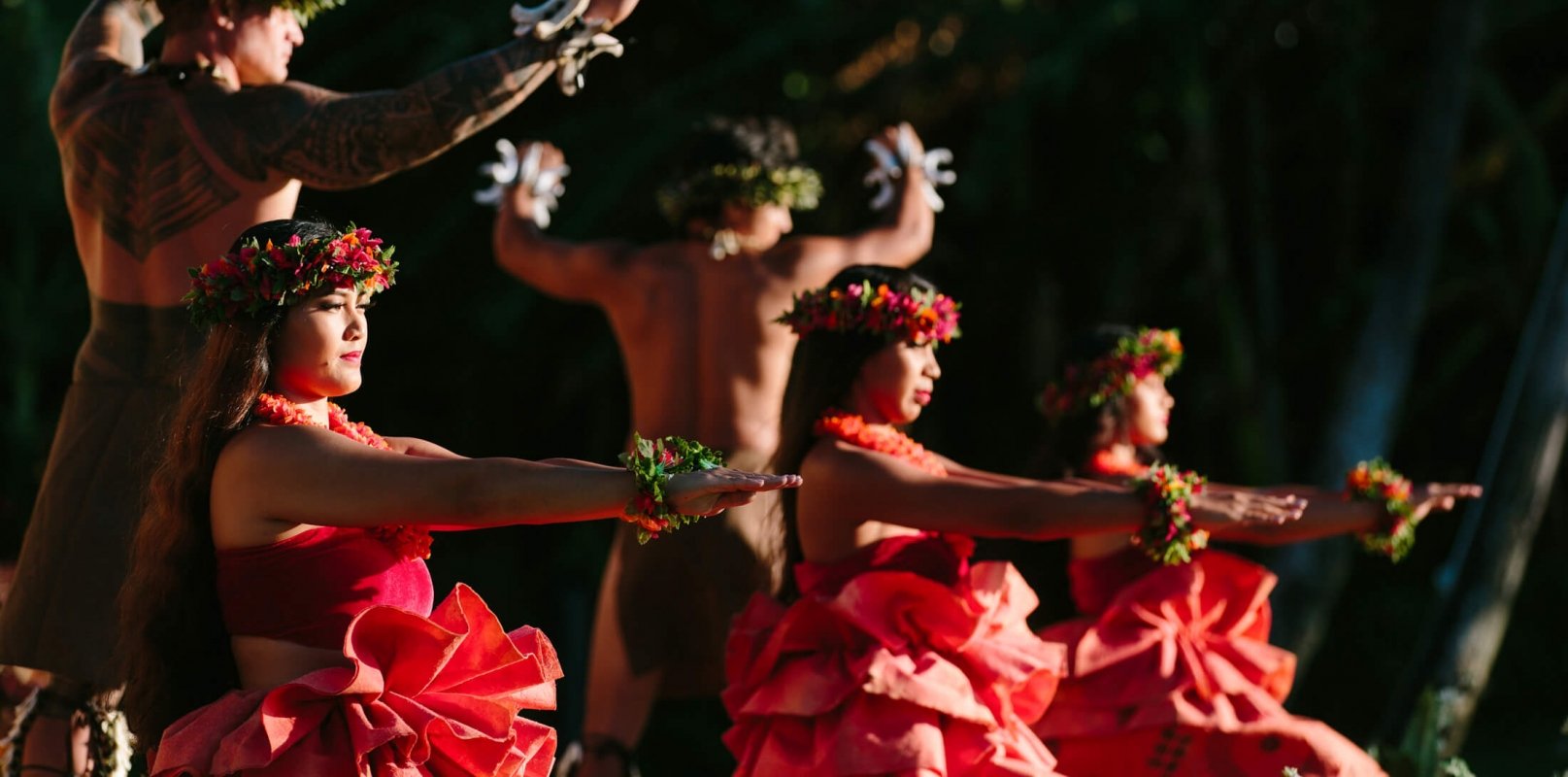 a group of women in red and men dance on a stage