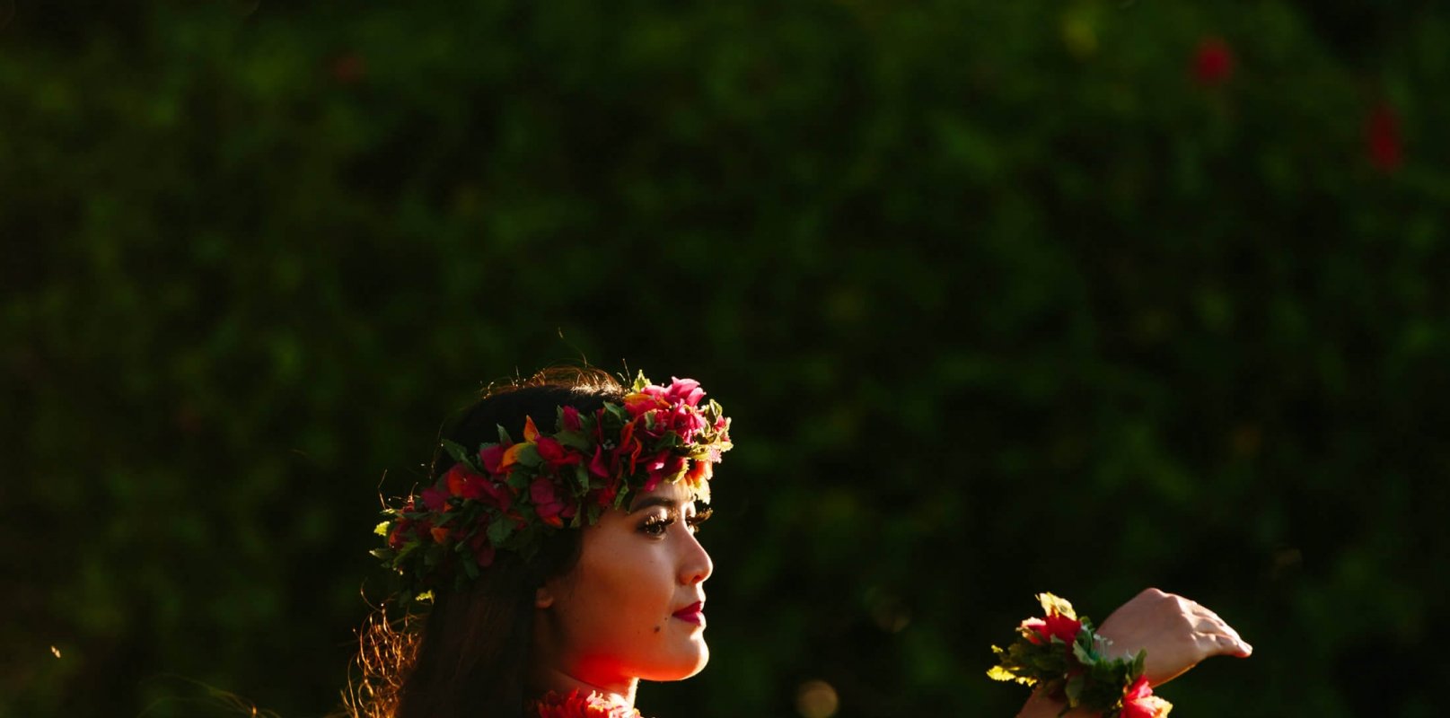 a woman dressed in red dances the luau outside 