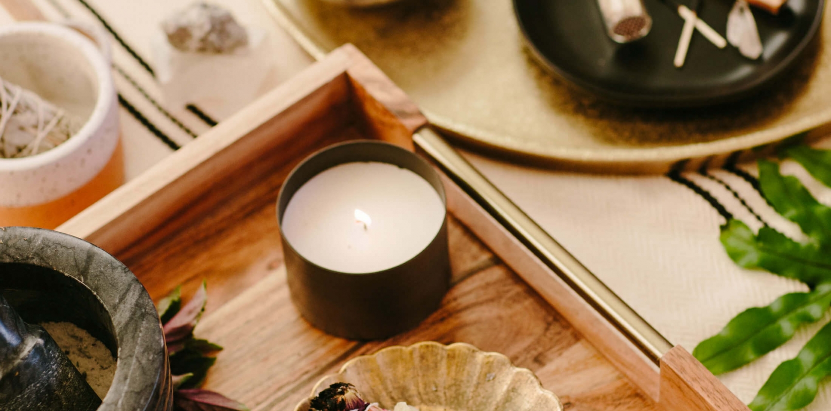 flatlay of candles, phone, and astrology reading on circular wooden table