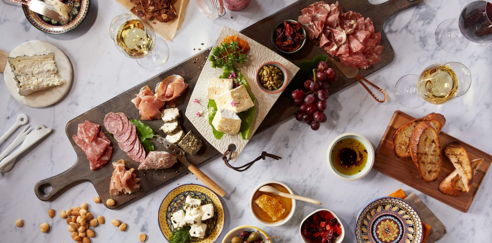charcuterie board surrounded by assorted dishes