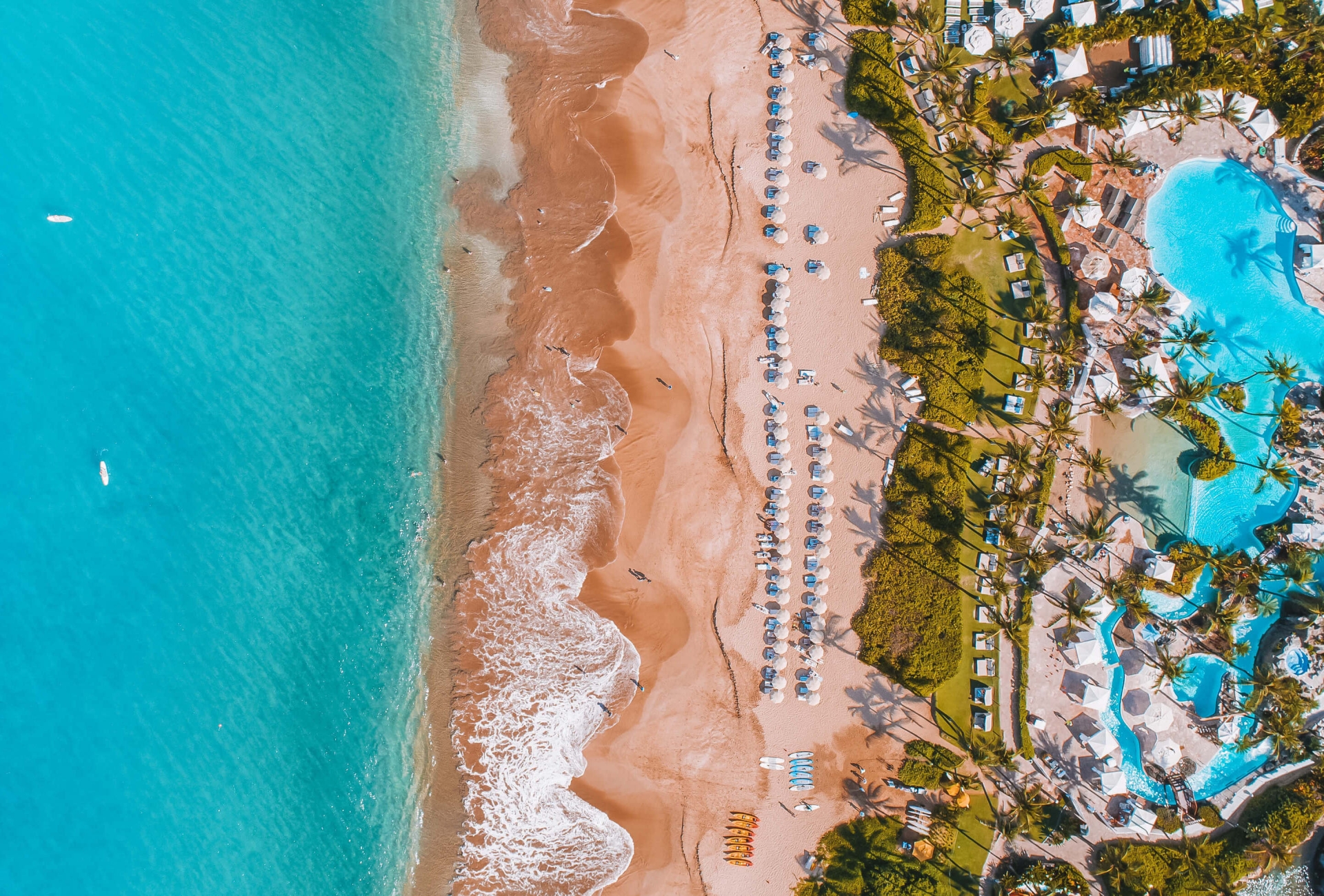 aerial view of Grand Wailea resort and pool with beach and ocean to the left 