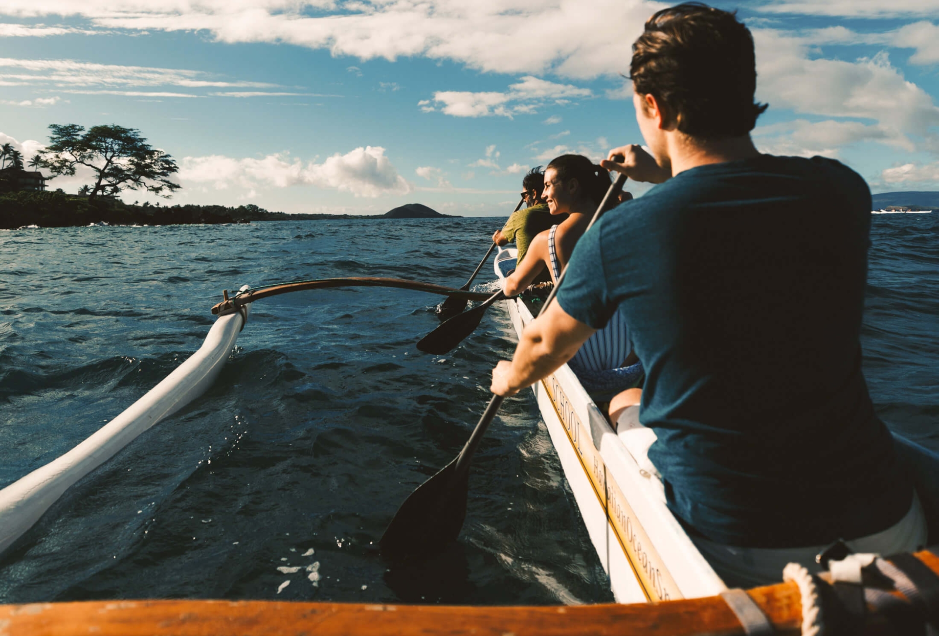 a person in an outrigger canoe against faces the open water below a cloudy sky