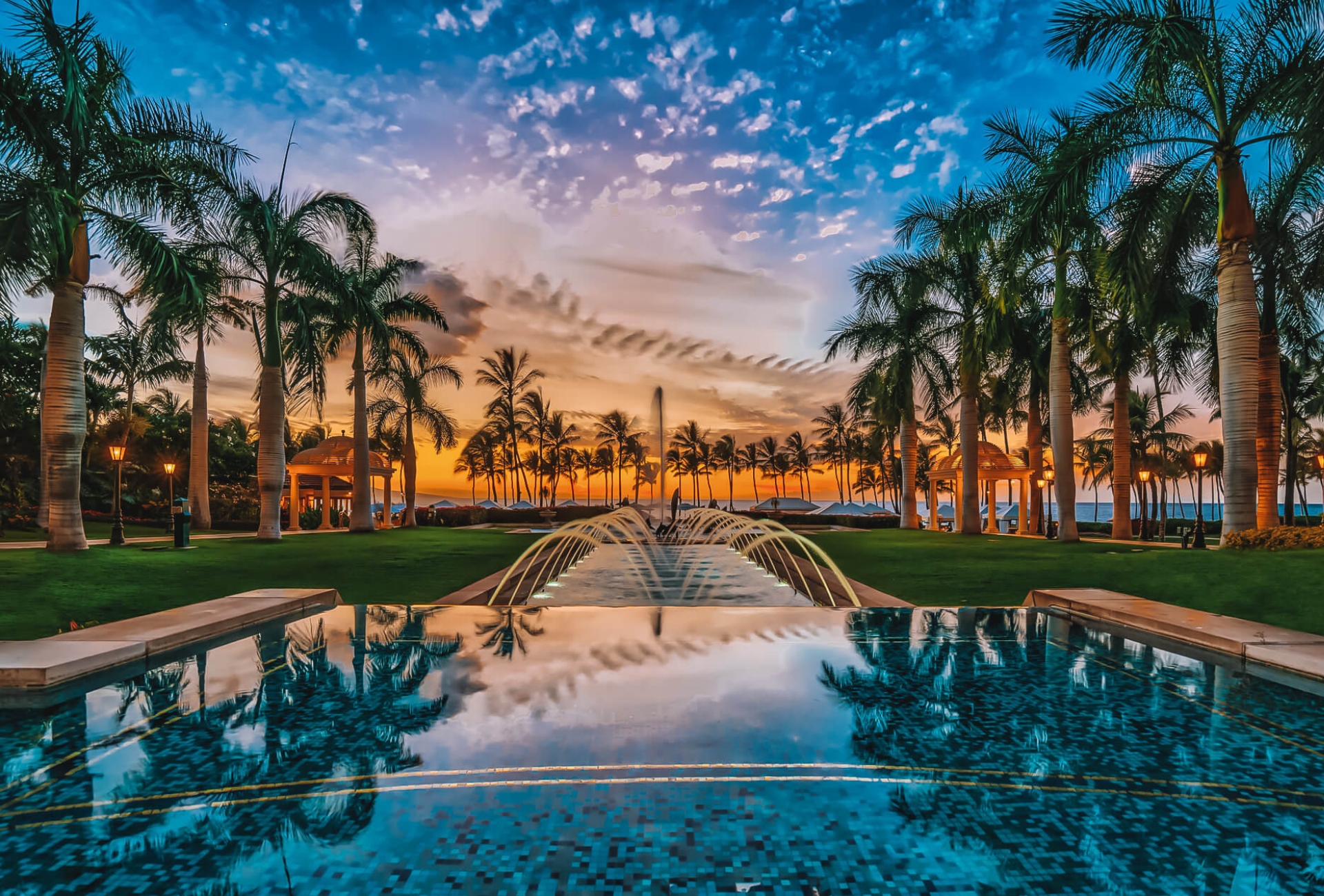 view of the Grand Wailea resort and pool with a dark blue and orange sky