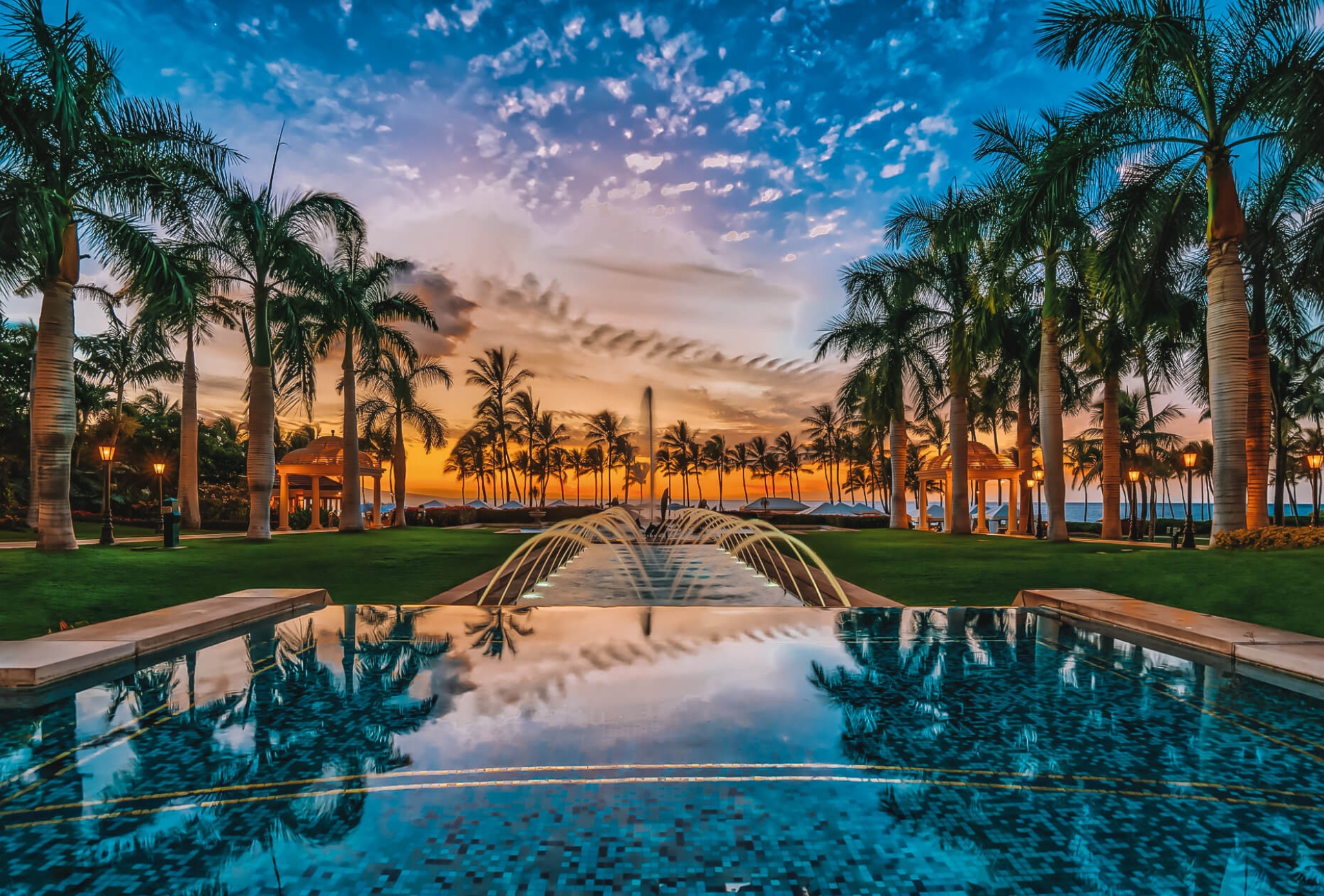 view of the Grand Wailea resort and pool with a dark blue and orange sky