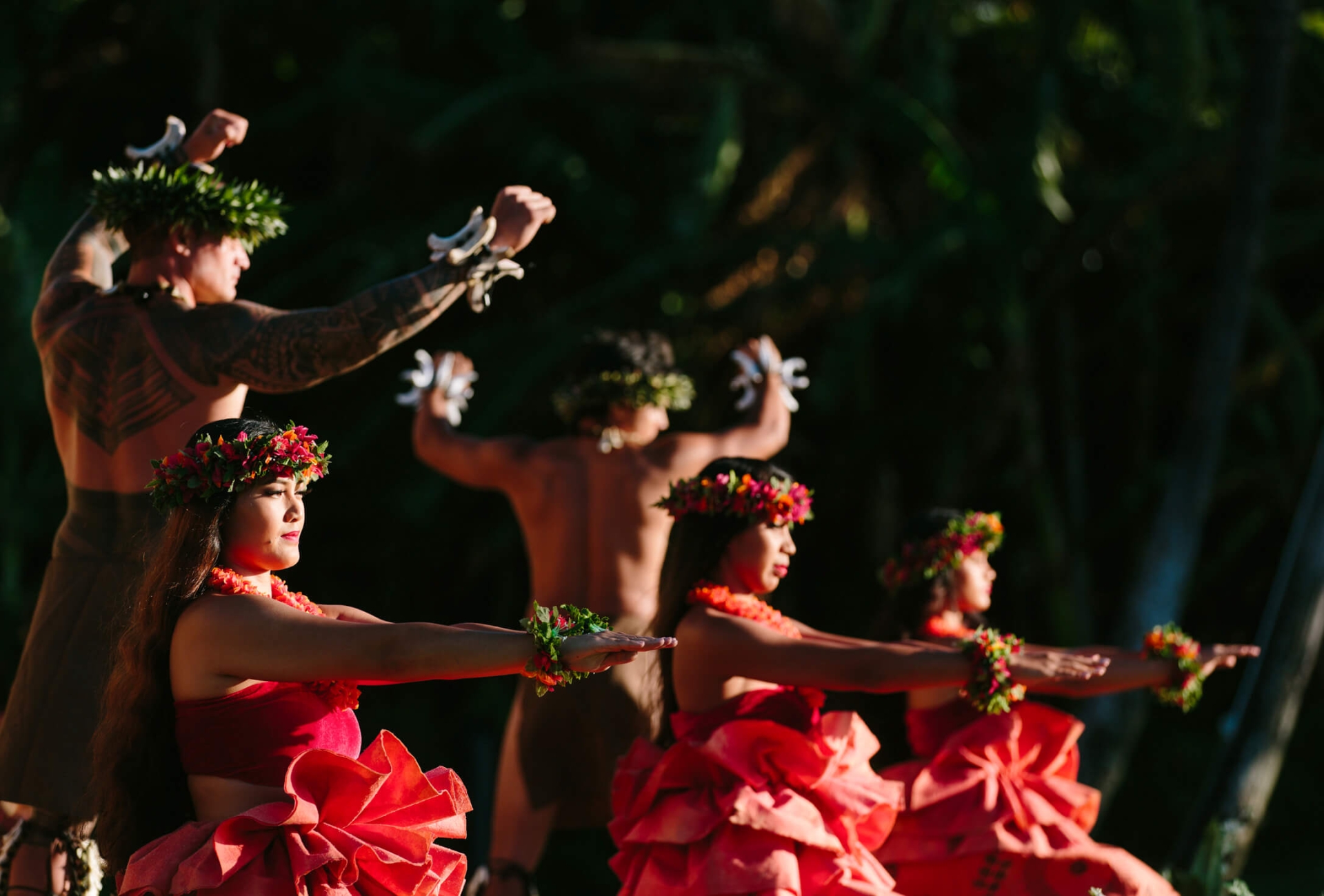 a group of women in red and men dance on a stage