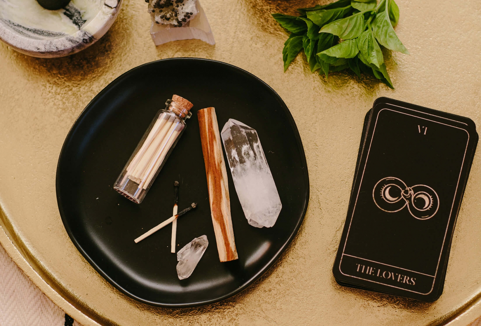 flatlay of candles, phone, and astrology reading on circular wooden table