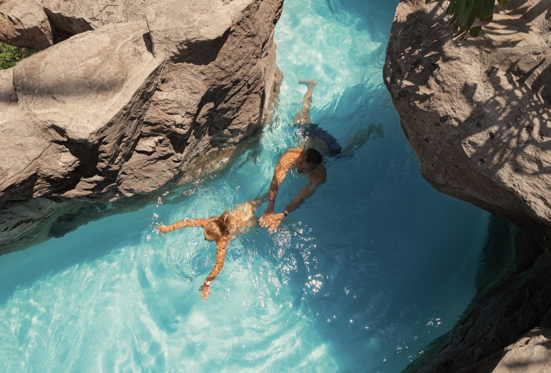 Two people swimming in the lazy river 