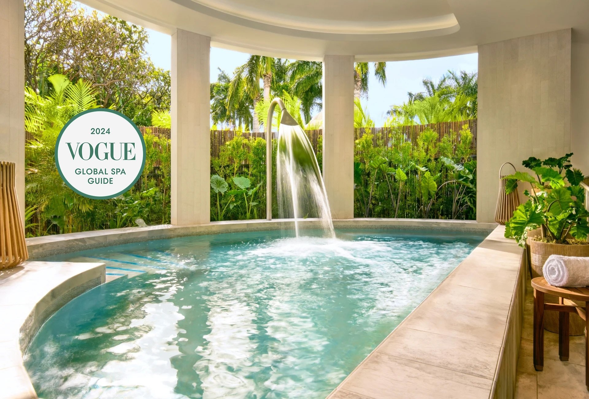 This is a beautiful image of the Hydrothermal Gardens pool at the Kilolani spa, showing the pool surrounded by bright, natural greenery. 