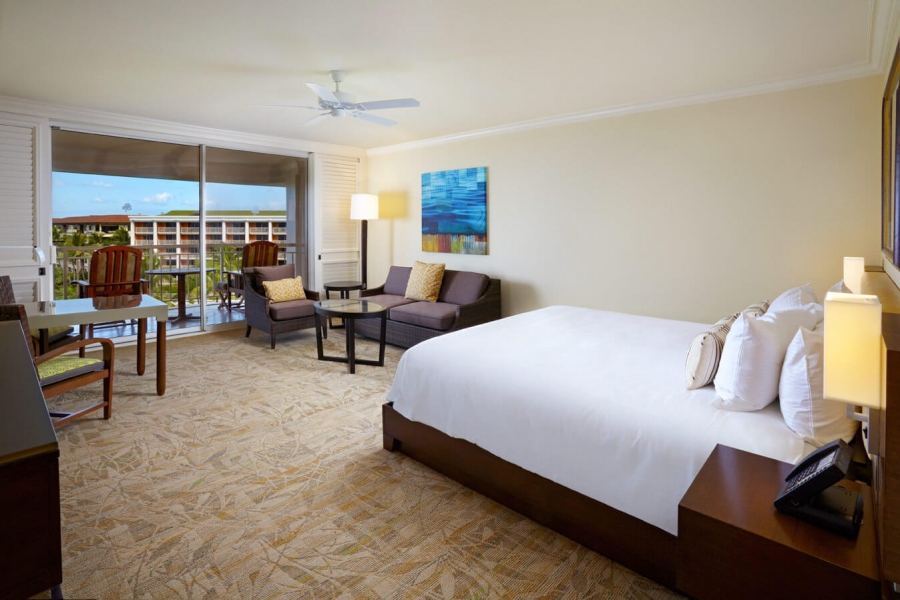 king bed and seating area in Napua Ocean View King with patio doors give view of outside