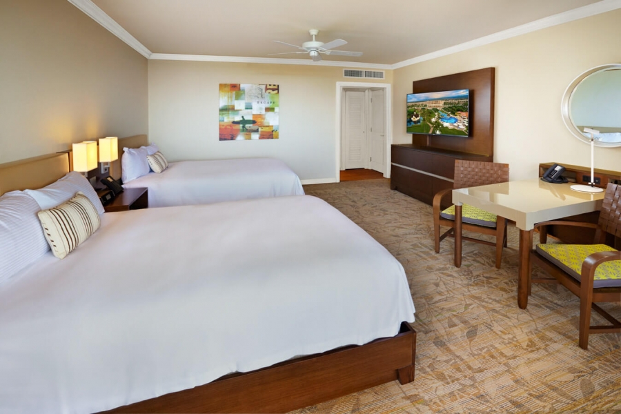two beds and seating area in Napua Ocean view Queen room with patio doors give view of outside