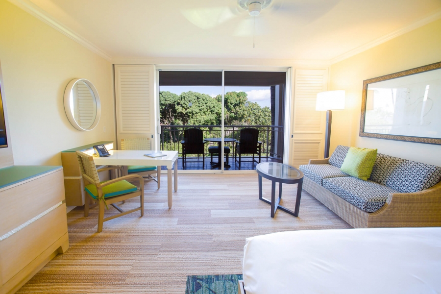 bed and seating area in King Garden view room with patio doors give view of outside