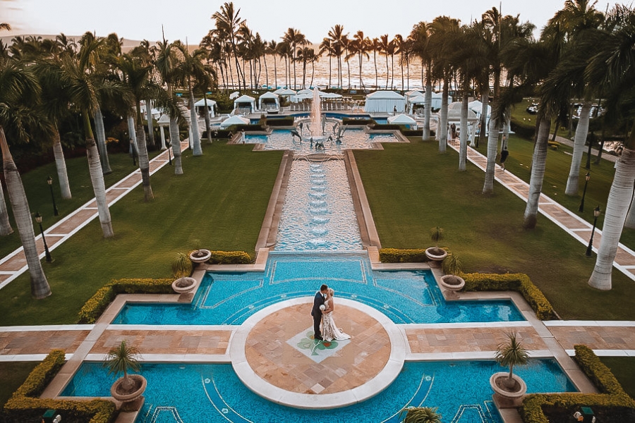 bride and groom stand on platfrom in the middle of Grand Wailea pool