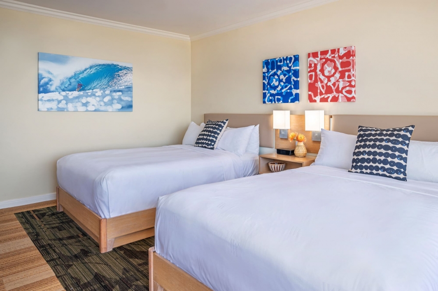 two beds in Garden Queen room with bedside table and artwork on the walls