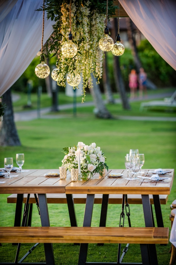 chairs sit around wooden table with white curtains pulled to each corner of pergola stands on the grounds of Grand Wailea resort