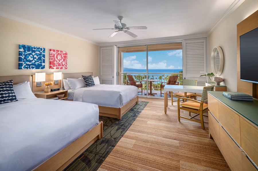 two beds and seating areas in Deluxe Ocean View Queen room with patio doors give view of outside